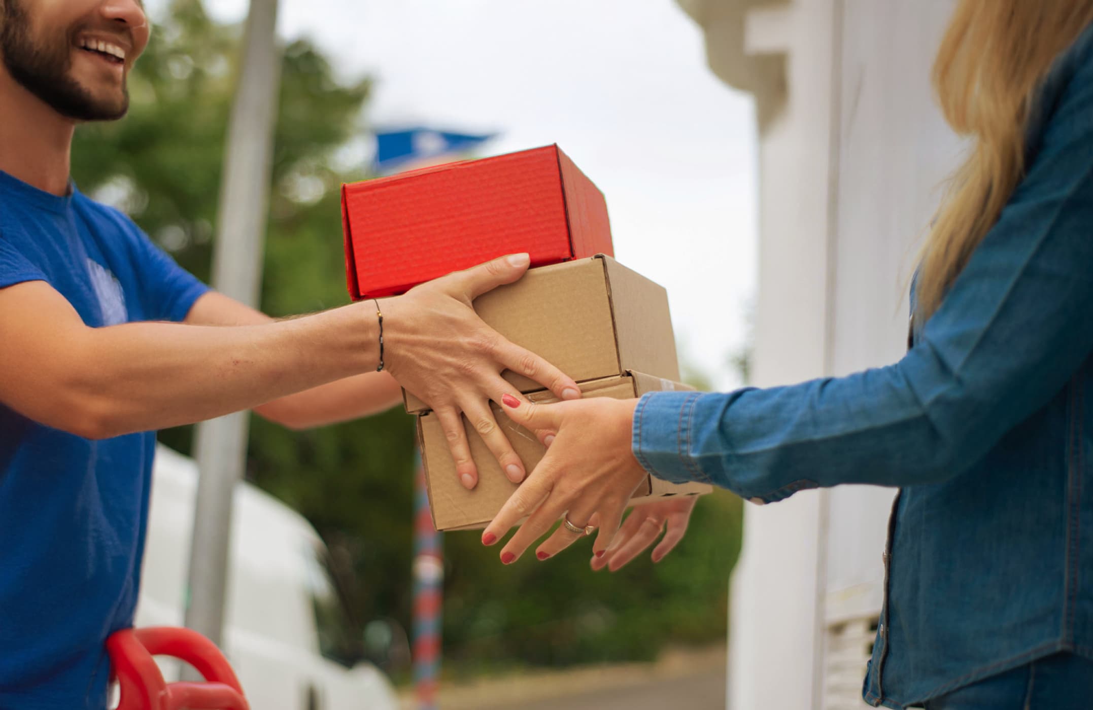 Governance & Compliance Mann von einem Lieferdienst übergibt einer Frau drei Pakete