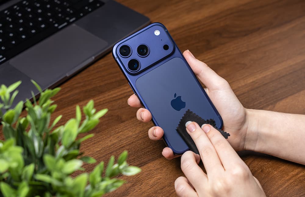iPhone 17 Pro Max in Deep Blue wird mit einem Mikrofasertuch geputzt