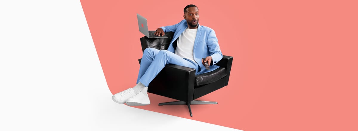 Wingo Charles auf Sessel mit Laptop und Fernbedienung