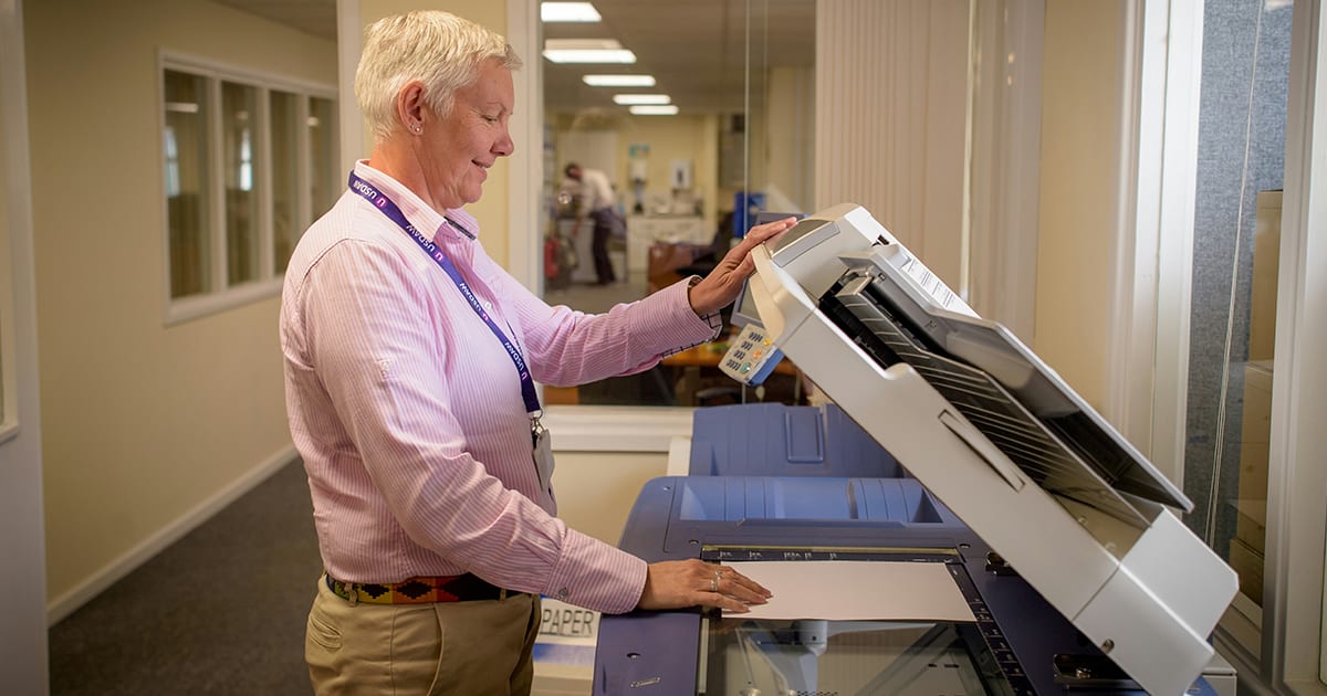 Frau scannt Dokument klassisch an Scanner